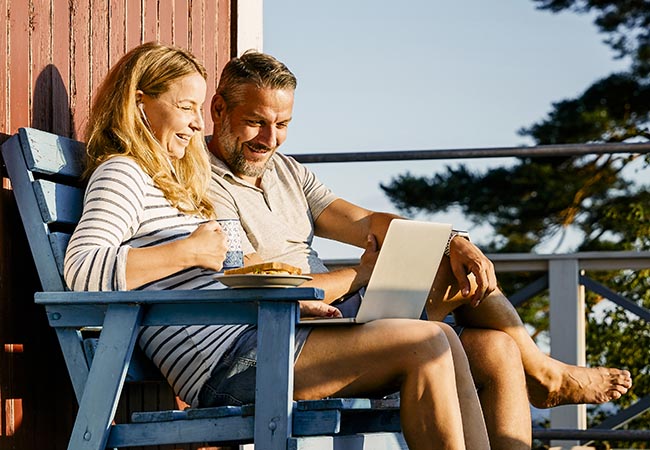 Couple looking at laptop on a deck